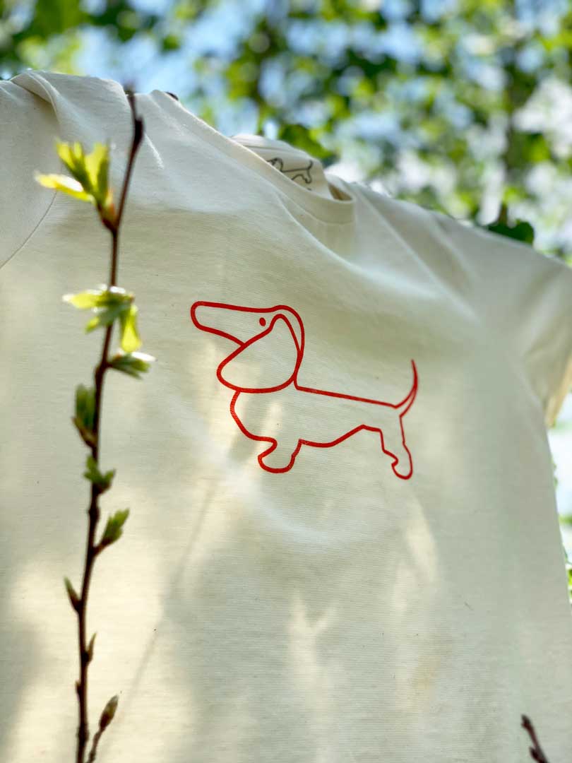 ein T-Shirt mit rotem Hund hängt in einem Baum